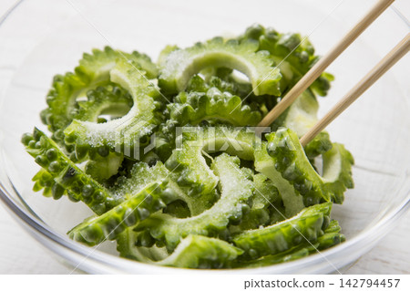 將苦瓜放入玻璃碗中,用鹽搓揉處理。 將苦瓜放入玻璃碗中,用鹽搓揉處理。 142794457