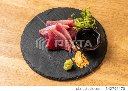 精美的鮪魚刺身盛放在黑色石盤中。 精美的鮪魚刺身盛放在黑色石盤中。 142794470