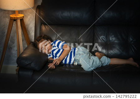 sleepy preschool child girl sleeping while watching tv in the living room at night 142795222