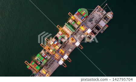 Aerial view container cargo ship loading unloading at night, Container cargo ship import export sea port, Global trade business container cargo ship freight shipping commercial trade logistic Aerial view container cargo ship loading unloading at night, Container cargo ship import export sea port, Global trade business container cargo ship freight shipping commercial trade logistic 142795704