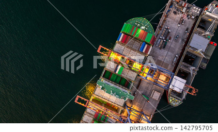 Aerial view container cargo ship loading unloading at night, Container cargo ship import export sea port, Global trade business container cargo ship freight shipping commercial trade logistic Aerial view container cargo ship loading unloading at night, Container cargo ship import export sea port, Global trade business container cargo ship freight shipping commercial trade logistic 142795705