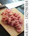 Sliced fermented pork sausage (naem) arranged on a wooden cutting board. 142796364
