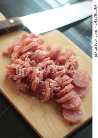 Sliced fermented pork sausage (naem) arranged on a wooden cutting board. Sliced fermented pork sausage (naem) arranged on a wooden cutting board. 142796364