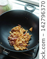 Thai-style omelet with fermented pork sausage (naem) cooking in a hot frying pan. 142796370