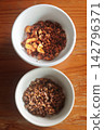 Pork crackling chili dip and ground fish chili dip in small white bowls on a wooden table. 142796371