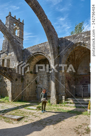 Female tourist posing under the arches of the ruins of Santa Marina de Dozo in Cambados, Female tourist posing under the arches of the ruins of Santa Marina de Dozo in Cambados, 142796484
