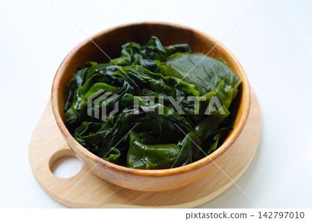 Fresh green wakame seaweed on a white background. Fresh green wakame seaweed on a white background. 142797010