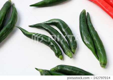 Fresh red and green chili peppers on a white Fresh red and green chili peppers on a white 142797014