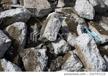 A large pile of broken concrete debris and shattered pavement at a road construction site. A large pile of broken concrete debris and shattered pavement at a road construction site. 142797210
