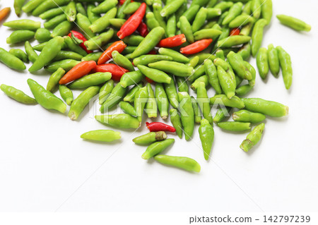 Fresh bird's eye chilies on white background. Fresh bird's eye chilies on white background. 142797239