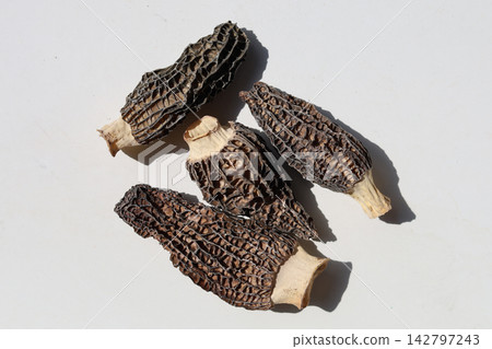 Dried morel mushrooms on white background. Dried morel mushrooms on white background. 142797243