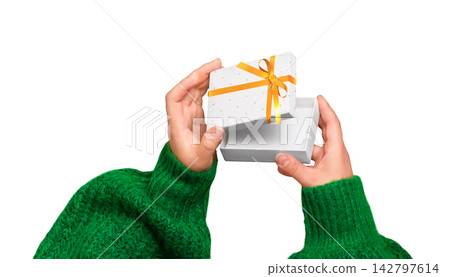 Female hands in green sweater holding a small white gift box with gold ribbon isolated on white background with copy space for holidays and celebrations Female hands in green sweater holding a small white gift box with gold ribbon isolated on white background with copy space for holidays and celebrations 142797614
