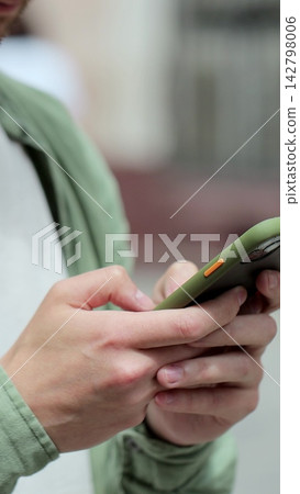Vertical video. Portrait of a man using a smartphone for messaging and social networking. Vertical video. Portrait of a man using a smartphone for messaging and social networking. 142798006