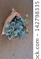 An overhead photograph of a fresh eucalyptus bouquet wrapped in English newspaper, placed on a wooden table. An overhead photograph of a fresh eucalyptus bouquet wrapped in English newspaper, placed on a wooden table. 142798335