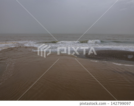 Dirty river water mixing with ocean after rainfall Dirty river water mixing with ocean after rainfall 142799097