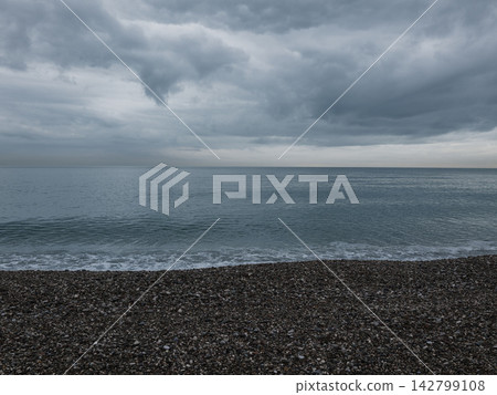 Calm sea under approaching storm clouds Calm sea under approaching storm clouds 142799108