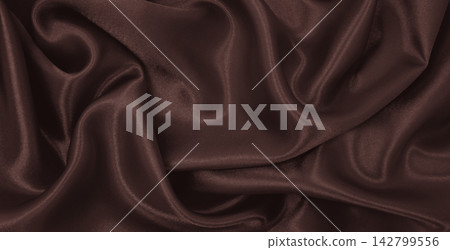 Smooth elegant brown silk or satin luxury cloth texture as abstract background. Luxurious background design. In Sepia toned. Retro style Smooth elegant brown silk or satin luxury cloth texture as abstract background. Luxurious background design. In Sepia toned. Retro style 142799556
