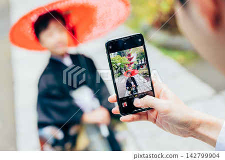 父母用智慧型手機拍照,記錄孩子七五三節的美好回憶。 父母用智慧型手機拍照,記錄孩子七五三節的美好回憶。 142799904