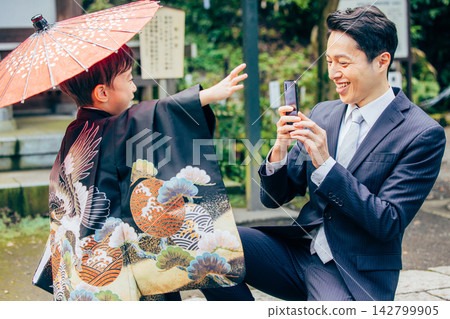 父母用智慧型手機拍照,記錄孩子七五三節的美好回憶。 父母用智慧型手機拍照,記錄孩子七五三節的美好回憶。 142799905