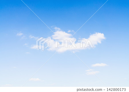 Clouds float in bright blue sky on a clear day in an open area with few visible clouds Clouds float in bright blue sky on a clear day in an open area with few visible clouds 142800173