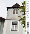 Traditional European House Facade with Shingle Cladding and Green Trim 142800269