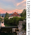 Historic Riverside House and Weir Under Colorful Sunset Sky 142800271