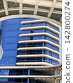 Modern Blue Glass Building with Curved White Balconies 142800274