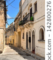 Narrow Mediterranean Street with Stone Houses and Iron Balconies 142800276