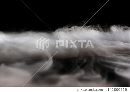 Dry ice smoke and fog spread across a black background. Dry ice smoke and fog spread across a black background. 142800356