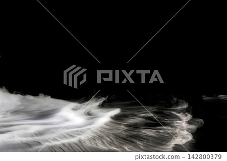Dry ice smoke and fog spread across a black background. 142800379