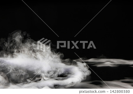 Dry ice smoke and fog spread across a black background. 142800380