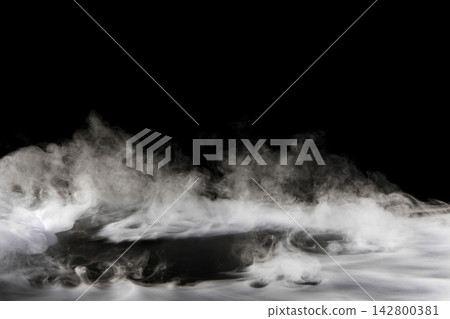 Dry ice smoke and fog spread across a black background. Dry ice smoke and fog spread across a black background. 142800381