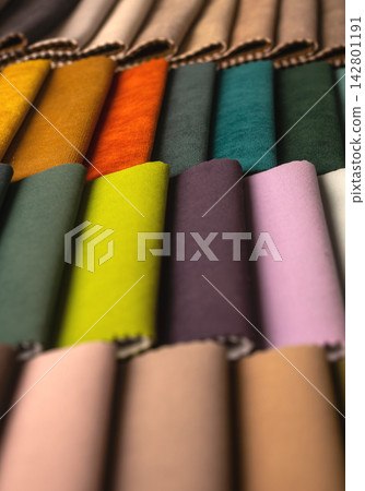 Rolled fabric samples in vibrant colors close up. Vertical stack of textile swatches for upholstery Rolled fabric samples in vibrant colors close up. Vertical stack of textile swatches for upholstery 142801191
