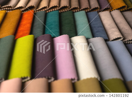 Rolled fabric swatches arranged in a colorful spectrum. Textile samples showing rich hues for Rolled fabric swatches arranged in a colorful spectrum. Textile samples showing rich hues for 142801192