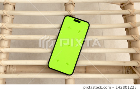 Smartphone with a bright green screen rests diagonally across rustic wooden pallet slats. The chroma 142801225