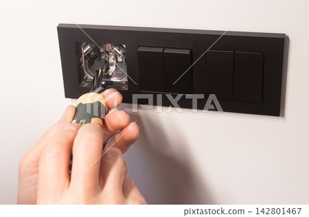 electrician repairing electrical outlet 142801467