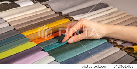 Hand selecting fabric swatch 142801495