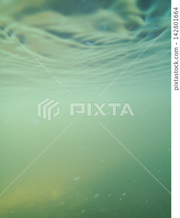 Calm turquoise water surface creates soft light waves over deep subaquatic space. Abstract 142801664