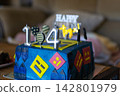 Vibrant blue 14th birthday cake featuring silver candles and playful geometric designs evokes youthful energy and gaming fun. Ideal for a teenage milestone celebration. Nobody. 142801979