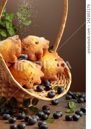 Freshly baked blueberry muffins in elegant basket. Freshly baked blueberry muffins in elegant basket. 142802176