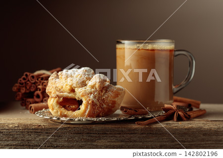 Viennese strudel and coffee latte on an old wooden table. Viennese strudel and coffee latte on an old wooden table. 142802196