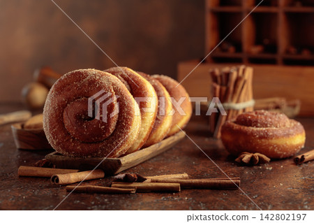 Swedish cinnamon rolls on a brown background. Swedish cinnamon rolls on a brown background. 142802197