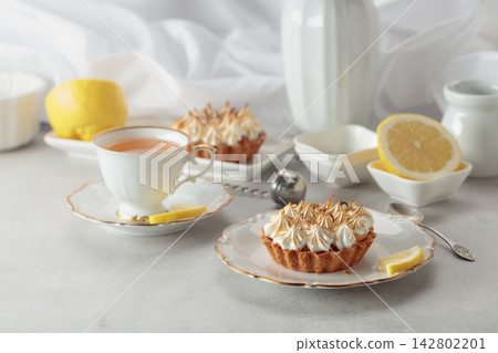 Meringue lemon tart on a white table. Meringue lemon tart on a white table. 142802201