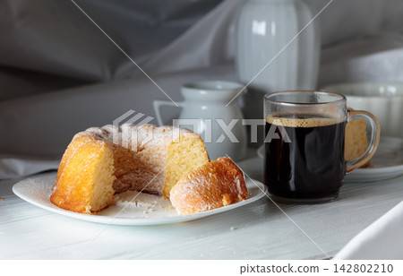 Easter cake sprinkled with powdered sugar and black coffee. Easter cake sprinkled with powdered sugar and black coffee. 142802210