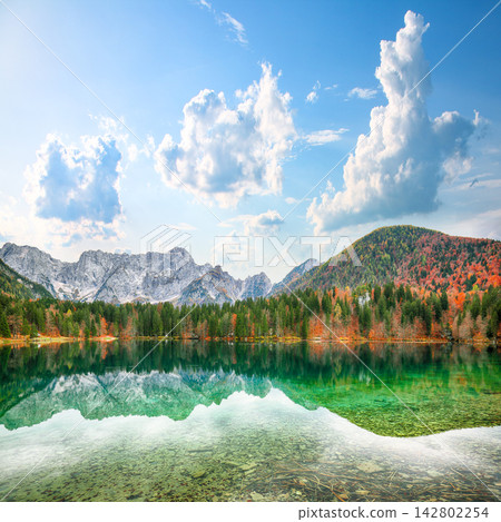 Stunning view of Fusine lake with Mangart peak on background. Stunning view of Fusine lake with Mangart peak on background. 142802254