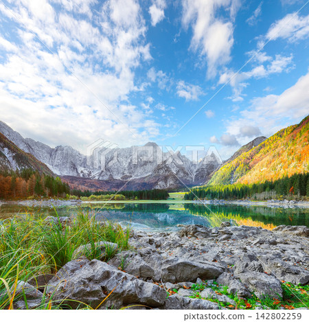 Stunning view of Fusine lake with Mangart peak on background. Stunning view of Fusine lake with Mangart peak on background. 142802259
