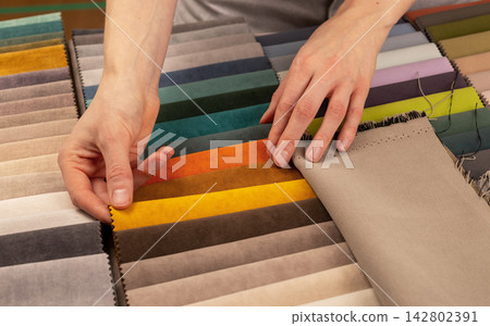 Interior design color palette choice for modern furniture. Person touching soft upholstery fabric Interior design color palette choice for modern furniture. Person touching soft upholstery fabric 142802391