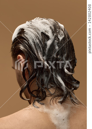 Close rear view of long male hair covered with shampoo foam. Close rear view of long male hair covered with shampoo foam. 142802408