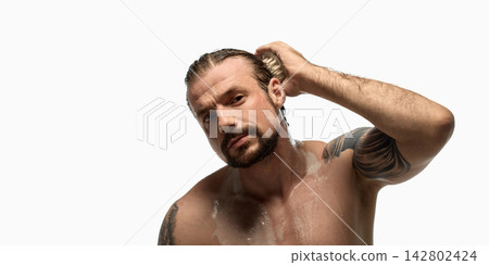 Bearded man massaging wet scalp after washing hair Bearded man massaging wet scalp after washing hair 142802424