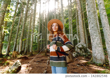 Woman with backpack hiking outdoors in the Forest. Trekking in the Pine Woods. Hiking lifestyle 142802546